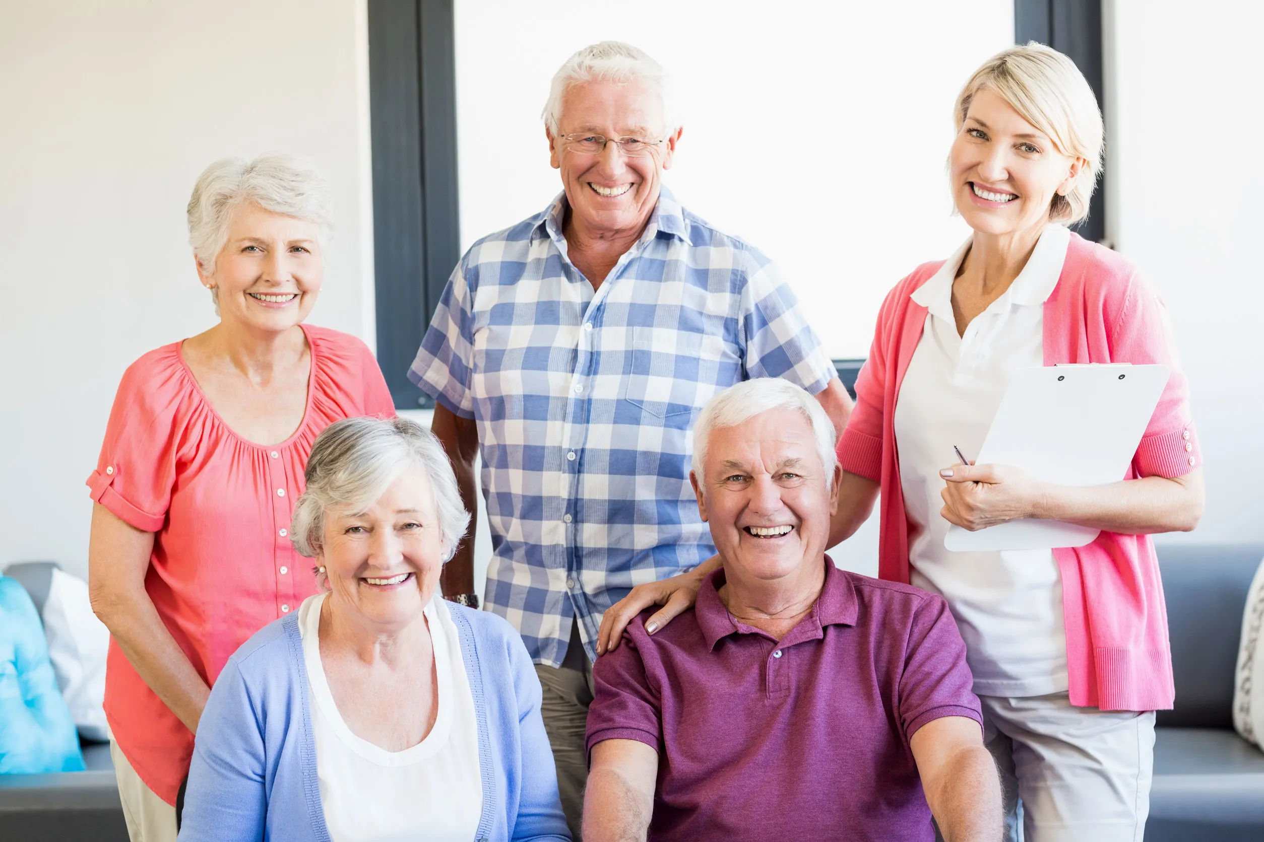 Nurse and seniors standing together in a retirement home Nurse and seniors standing together in a retirement home